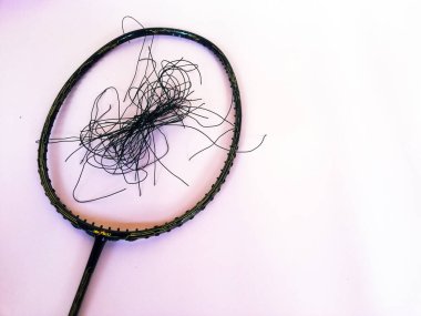 Bali,Indonesia - July 23,2022: Badminton racket with a broken strings,on color background