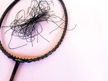 Bali,Indonesia - July 23,2022: Badminton racket with a broken strings,on color background