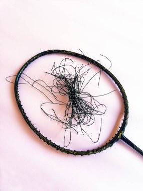 Bali,Indonesia - July 23,2022: Badminton racket with a broken strings,on color background