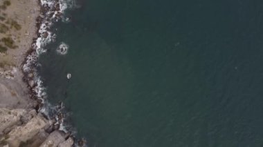 Karadeniz kıyısı, Kırım. 16 bölümün 16 'sında kameranın sudan ufka yükselişi. Kayalık kıyılar, mavi sular, su yüzeyini kesen tekneler. Atış yeri Cape Kapchik, Sudak 'a yakın bir tatil köyü. 4K video, renk korrosu yok.