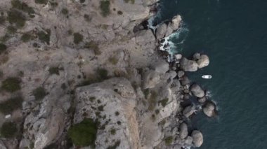 Karadeniz kıyısı, Kırım. 16 bölümün 15 'i - kayaların ve denizin en üst görüntüsü. Kayalık kıyılar, mavi sular, su yüzeyini kesen tekneler. Atış yeri Cape Kapchik, Sudak 'a yakın bir tatil köyü. 4K video, renk düzeltmesi yok.