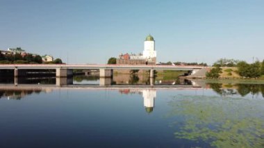 Vyborg Kalesi. Yedi. Suda ve köprünün altında trafik vardı. Vyborg 'un tarihi merkezi ve St. Olaf kulesi olan Vyborg kalesi. Yaz güneşli bir sabah. Renk notu yok.