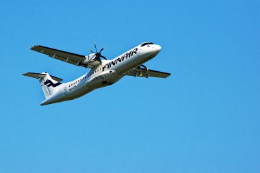 Letonya, Riga - 11.09.2021, Riga havaalanında mavi gökyüzünde beyaz-mavi Finnair yolcu uçağı.