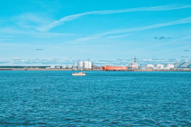 Güneşli bir günde, Baltık Denizi 'ndeki Ventspils limanı dalgakıranların arka planına karşı..