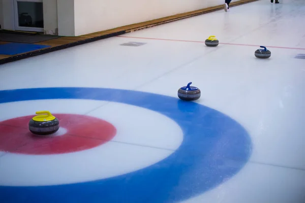 Kamień Curling Żółtą Rączką Siedzi Lodzie Centrum Domu Innymi Kamieniami — Zdjęcie stockowe