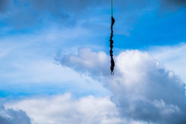 Bulutlu mavi gökyüzünün arka planında Sloka, Jurmala, Letonya 'da ip atlamak için bir dağ asılı duruyor..