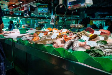 Spain, Barcelona - May 26 2022: On the ice lies fresh seafood - salmon, tuna, stingray, squid, mussels and others at the Boqueria Market in Barcelona. Small depth of field.