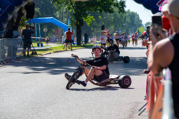 Jurmala, Kauguri, Latvia - August 14 2022: Close-up of race on track with paints. Spectators behind the fence. The color run.