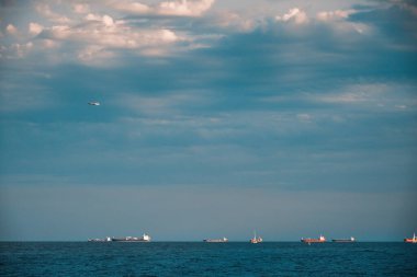 Barcelona, Spain - May 29 2022: On the horizon of the Barearic Sea, cargo ships leave the port of Barcelona.