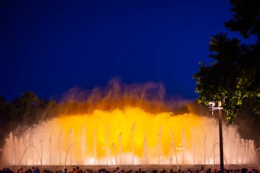 Barcelona, Spain - May 28 2022: Night Photograph Of The Performance Of The Singing Magic Fountain Of Montjuic In Barcelona, Catalonia, Spain. Crowd Of People Are Watching The Performance.