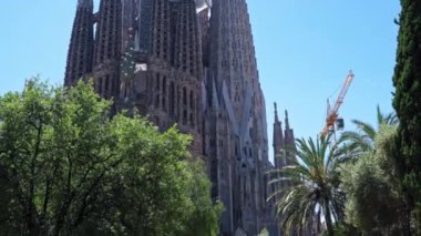 Barselona, İspanya - 28 Mayıs 2022: İnşaat sırasında ünlü Sagrada Familia Bazilikası 'nın çekimi. Parktan görüntüle.