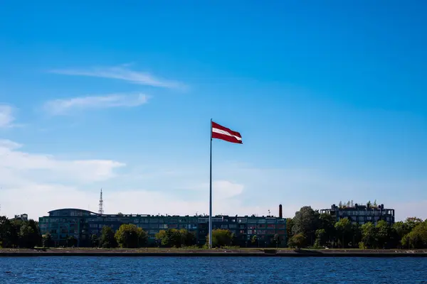 Bandeira Letã Pendurada Flagpole Contra Céu Azul Nas Margens Rio — Fotografia de Stock