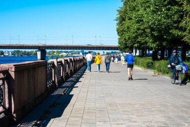 Riga, Letonya - 09 10 2022: İnsanlar Daugava boyunca gezinti güvertesinde yürüyor. Yüksek kalite fotoğraf