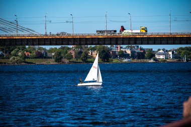 Riga, Letonya - 09102022: Yelkenli Teknedeki Adam Daugava nehri yakınlarındaki Kablo Kalıcı Köprü. Yüksek kalite fotoğraf