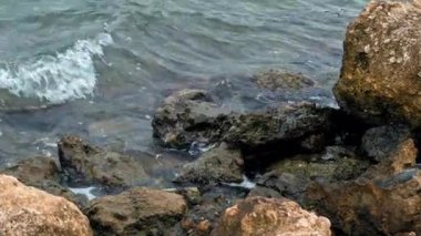 Huzursuz İyon Denizi, İskele, Moraitika, Korfu, Yunanistan 'ın Taşlarında Köpüklü Dalgalar. Tatil köyünde kötü hava kavramı. Yüksek kalite 4k görüntü