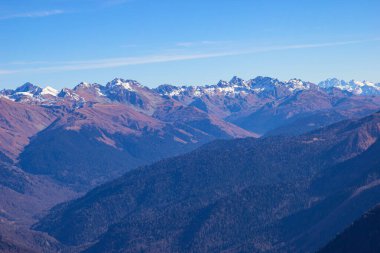 Görkemli dağ sırasının manzarası, mavi gökyüzüne karşı keskin tepeler yükseliyor. Gül Tepesi, Soçi, Rusya