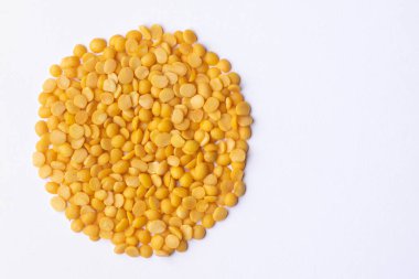 Kuru Bezelye Darbeleri ikiye bölündü ve beyaz arka planda dairesel biçimde yayıldı. Dal, dal tadka vb gibi çeşitli mutfaklarda kullanılır. Kullanılan seçici odak.