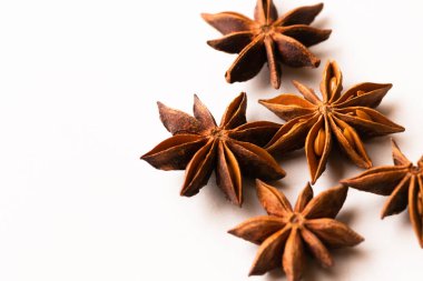 Fotokopi alanı ve seçici odak ile beyaz arkaplanda yıldız anason kurutulmuş baharat kapsülleri.