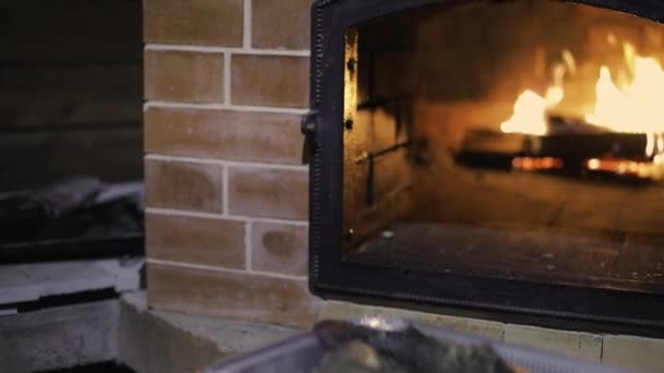 A man prepares raw fish in a brick oven. — Stock Video