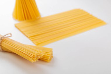 Beyaz arka planda iplikle bağlanmış çiğ spagetti paketleri. İtalyan gıda konsepti.