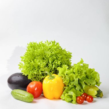 Beyaz arka planda taze çiğ sebzeler. Salata, domates, salatalık, patlıcan, kabak..