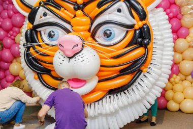 İnsanlar balonlardan yeni yıl kaplanı şekli yaratıyor. Yeni 2022 'nin sembolü.