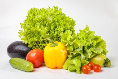 Beyaz arka planda taze çiğ sebzeler. Salata, domates, salatalık, patlıcan, kabak..