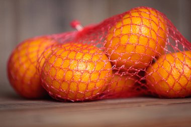 Ahşap bir arka planda mandalinalarla örülü. Noel ziyafeti.