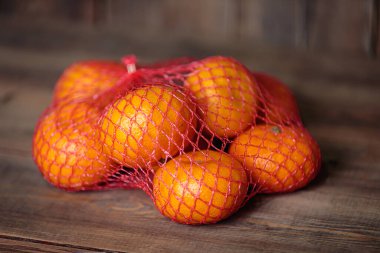 Ahşap bir arka planda mandalinalarla örülü. Noel ziyafeti.