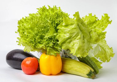 Beyaz arka planda taze çiğ sebzeler. Salata, domates, salatalık, patlıcan, kabak..
