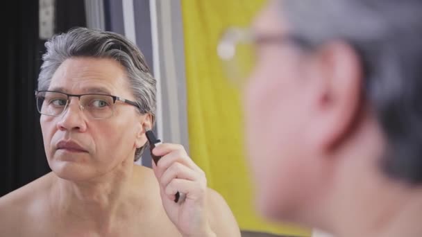 Adult Gray Haired Man Removes Hair His Ears Trimmer Close — Wideo stockowe