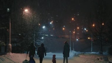 Akşamları parkta yürüyüş yapan bir aile. Şiddetli kar yağışı. Zelenograd, Rusya 28.01.2022.