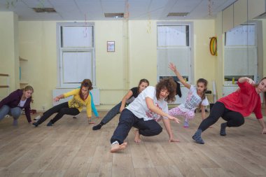 Bir grup öğrenciyle birlikte koç koridorda bir dans hareketi öğreniyor. Rusya Zelenograd 28 Eylül 2017