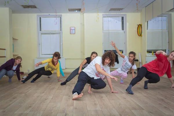 Bir grup öğrenciyle birlikte koç koridorda bir dans hareketi öğreniyor. Rusya Zelenograd 28 Eylül 2017