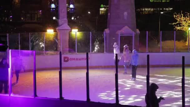 人们晚上在一个点着灯的冰球场上滑冰.下着暴风雪，下着雪。2022年1月28日 — 图库视频影像