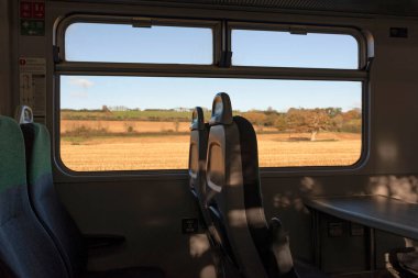 Devon, İngiltere, İngiltere. 2021 yılı. Tren Devonshire kırsalından geçerken manzaralı bir şekilde oturan yolcu treni. Dartmoor Hattı.