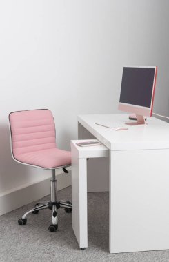 İngiltere, İngiltere. 2021 yılı. Beyaz bir ofis masası ve pembe bir sandalye, fareli masaüstü bilgisayarı ve klavyesi. 