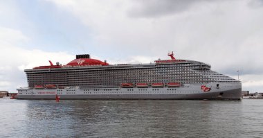 Portsmouth, İngiltere, İngiltere. 2022 yılı. Seyir gemisi Valient Lady Portsmouth Limanı İngiltere 'den ayrılıyor. HMS Kraliçe Elisabeth uçak gemisini geçiyoruz.