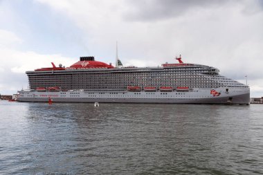 Portsmouth, İngiltere, İngiltere. 2022 yılı. Seyir gemisi Valient Lady Portsmouth Limanı İngiltere 'den ayrılıyor. HMS Kraliçe Elisabeth uçak gemisini geçiyoruz.