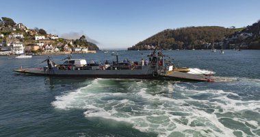 River Dart, Güney Devon, İngiltere, İngiltere. 2022 yılı. Düşük yolcu ve araç feribotu Dartmouth 'tan Kingswear' e giden Dart Nehri 'nden geçiyor. Yükleme rampası indiriliyor..