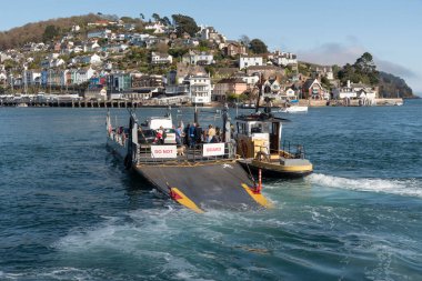 River Dart, Güney Devon, İngiltere, İngiltere. 2022 yılı. Düşük yolcu ve araç feribotu Dartmouth 'tan Kingswear' e giden Dart Nehri 'nden geçiyor. Yükleme rampası indiriliyor..