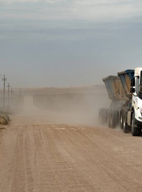 Overberg region, Western Cape, South Africa. 2022. Dirt road and dust flowing off the wheels of a truck in the Overberg region. South Africa.