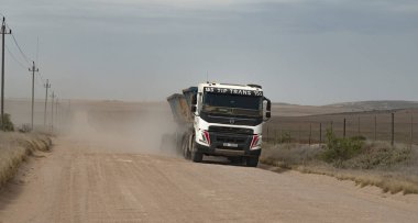 Overberg bölgesi, Batı Burnu, Güney Afrika. 2022 yılı. Overberg bölgesinde bir kamyon ve römorkun tekerlerinden akan toprak yol ve toz. Güney Afrika. 