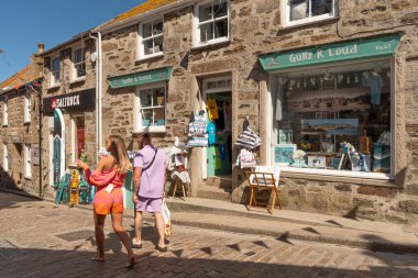 St Ives, Cornwall, İngiltere, İngiltere. 2022 yılı. Taşın dışındaki vitrinlere bakan turistler, İngiltere 'nin Cornwall kentindeki St. Ives şehir merkezinde dükkanlar inşa ettiler.
