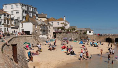 St Ives, Cornwall, İngiltere, İngiltere. 2022 yılı. St. Ives 'deki liman ve kasaba merkezine yakın küçük bir plajda tatil yapanlar Cornish sahil beldesi.,