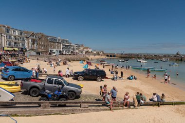 St Ives, Cornwall, İngiltere, İngiltere. 2022 yılı. Aziz Ives, popüler bir Cornish sahil beldesi. Kumsaldaki tatilciler ve kumsaldaki araçlar..