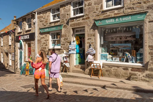 St Ives, Cornwall, İngiltere, İngiltere. 2022 yılı. Taşın dışındaki vitrinlere bakan turistler, İngiltere 'nin Cornwall kentindeki St. Ives şehir merkezinde dükkanlar inşa ettiler.