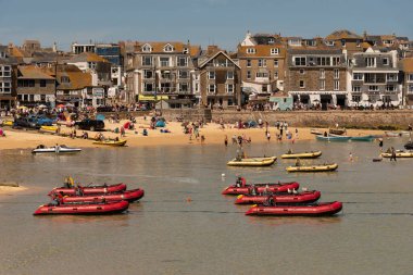 St Ives, Cornwall, İngiltere, İngiltere. 2022 yılı. Cornwall 'daki St. Ives' ın popüler sahil beldesi. Sığ sularda kendi kendine giden kırmızı şişme botlar..