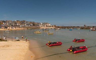 St Ives, Cornwall, İngiltere, İngiltere. 2022 yılı. Cornwall 'daki St. Ives' ın popüler sahil beldesi. Sığ sularda kendi kendine giden kırmızı şişme botlar..