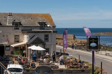 Sennen Koyu, Cornwall, İngiltere. 2022 yılı. Tatilciler St Ives Cornwall UK yakınlarındaki Sennen Koyu 'nda bir Cornish barının önünde yiyip içiyorlar.